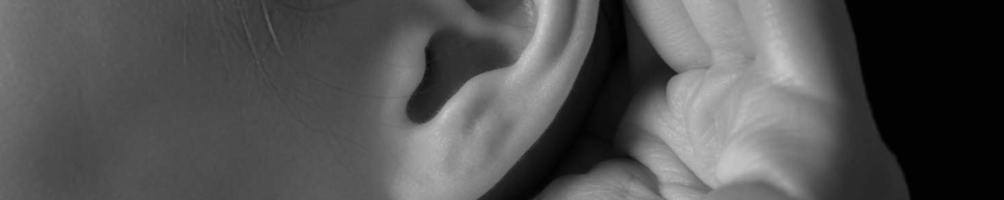Unrecognizable woman holds her hand near ear and listens, close-up